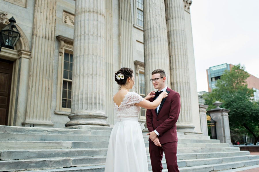 A bride straightens her grooms bowtie.
